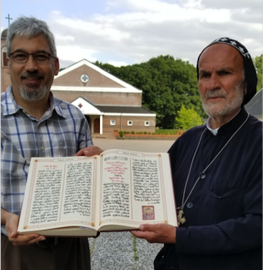 George Kiraz and Dayroyo Elio Atto holding an open copy of the Gospel Lectionary